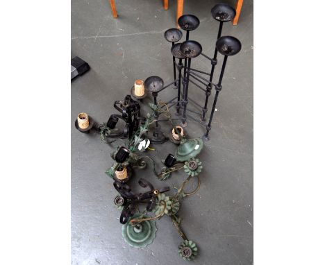 Two green metal chandeliers with scrolling arms and foliate design, with a black metal four light chandelier and seven candle