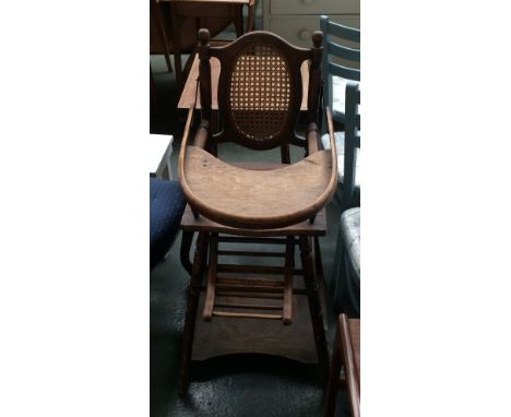 An Edwardian child's folding high chair with cane back and seat, turned legs and arms, folding table and ladder foot rest, th