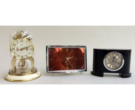 An anniversary clock along with two other stylised mantle clocks