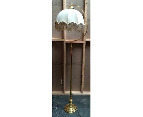 A brass standard lamp with shade