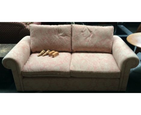 A modern chesterfield style sofa upholstered in floral fabric raised on turned oak legs, retailed by The Handmade Sofa Compan