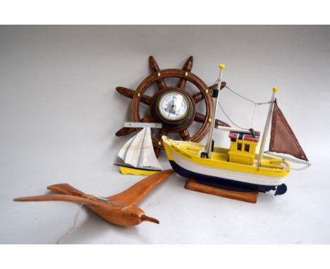 A barometer in the form of a ship's wheel 43cmD; a carved albatross, a wooden model of a boat and a dinghy