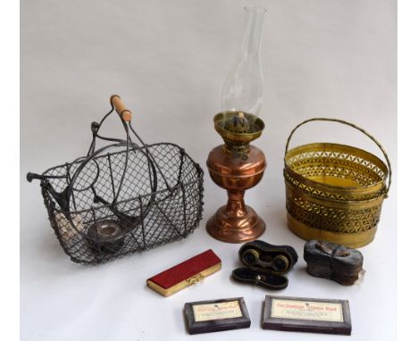 A copper oil lamp with glass chimney, two pierced brass planters, a wire egg basket, silver plate kettel stand, vintage glass