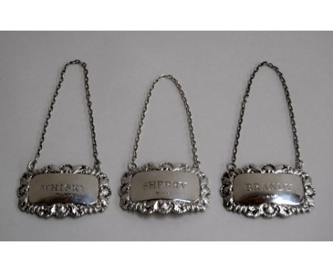 Three silver decanter labels reading Sherry, Whiskey, and Brandy, net weight 1.5oz, and a silver backed hair brush