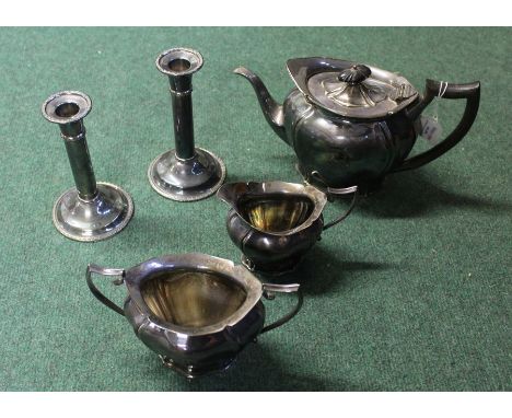 Silver plated three piece tea service, together with a pair of candlesticks, (5)