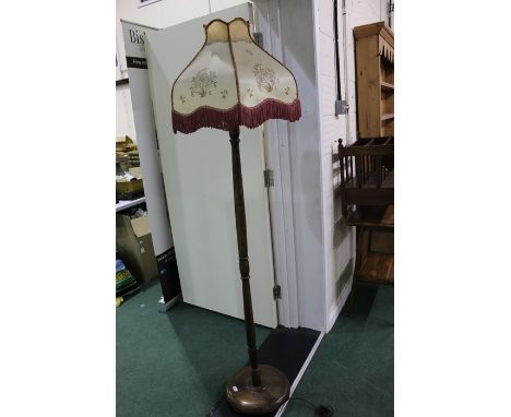 Mahogany standard lamp with tasselled shade and turned stem on a circular plinth base