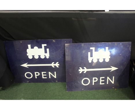 Railway interest, a pair of blue enamel signs each with a depiction of a train above an arrow (one left, one right) and the w