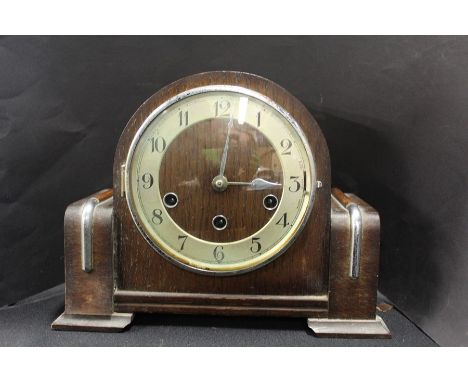 Ard Deco style mantle clock, the domed case with chrome mounts, the silvered dial with Arabic numerals, 29cm wide