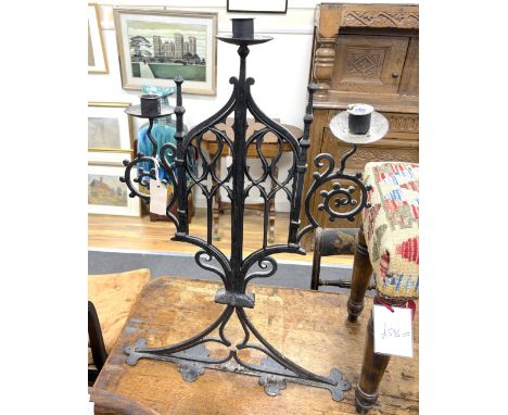 A pair of Gothic wrought iron three light candelabra, width 46cm, height 76cmProvenance- Brede Place chapel, East Sussex, a f