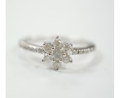 A modern 9ct white gold and diamond cluster set flower head ring, with diamond chip set shoulders, size R/S, gross weight 2.8