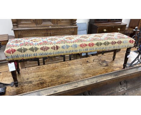 A Kilim covered long stool on turned beech legs, width 153cm, depth 34cm, height 47cm