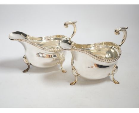 A pair of Elizabeth II silver sauceboats, with flying scroll handles, by Garrard & Co, London, 1961, length 17.9cm, 20oz.