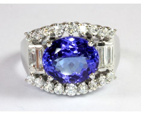 A 14ct white gold (stamped 585) ring set with an oval cut tanzanite (approx. 3.90ct) and brilliant and baguette cut diamonds 