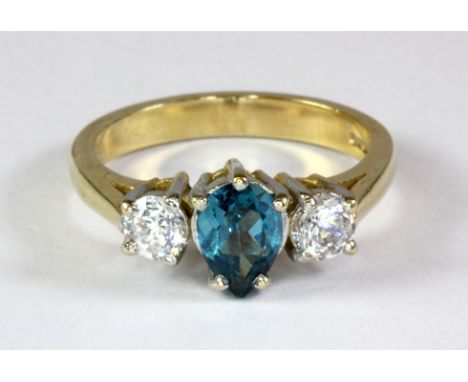 A lovely 9ct yellow gold ring set with a pear shaped London blue topaz and white stones (O).