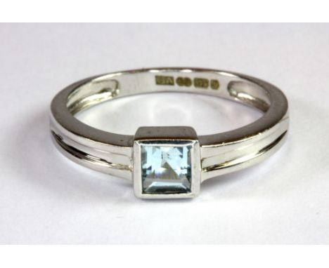 A 9ct white gold ring set with a princess cut blue topaz (M.5).