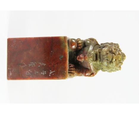 A large Chinese carved mixed colour soapstone seal mounted with a lion, H. 15cm.