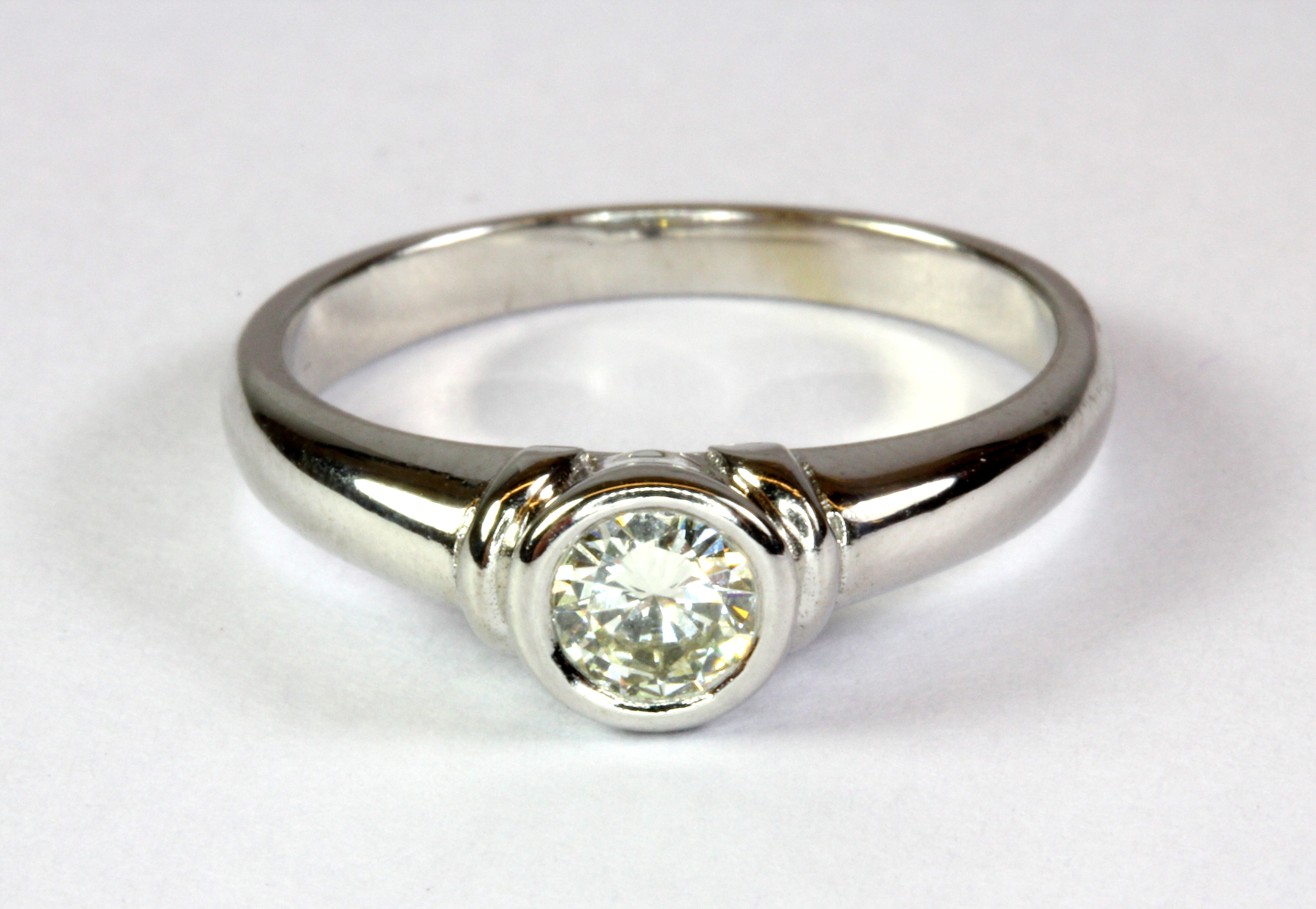 An 18ct white gold (worn stamp 18ct) diamond solitaire ring (J.5).