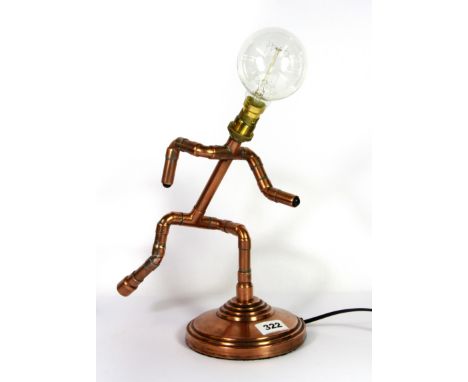 An interesting running man table lamp made from copper plumbers pipe, H. 37cm.