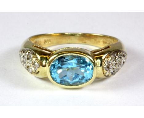 A 14ct yellow gold ring set with an oval cut blue topaz and white stone set shoulders (P).