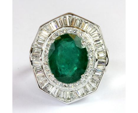 A stunning 18ct white gold (stamped 750) cluster ring set with an oval cut emerald (approx. 9.10ct) surrounded by diamonds (o