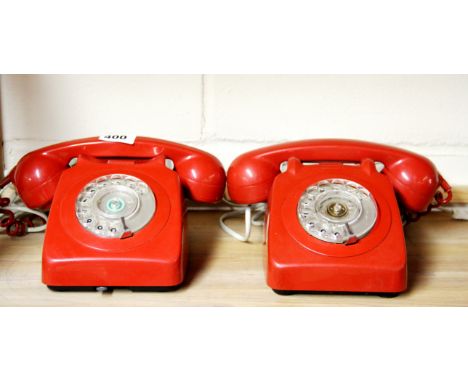 Two vintage red telephones.