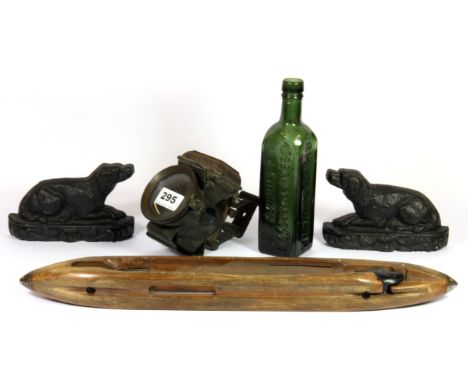 An early bicycle lamp, a pair of cast iron dog door stops, a Shieldhall green glass bottle and a weaving shuttle.