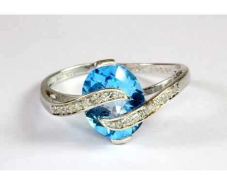 A 9ct white gold ring set with a blue topaz and diamonds (O).