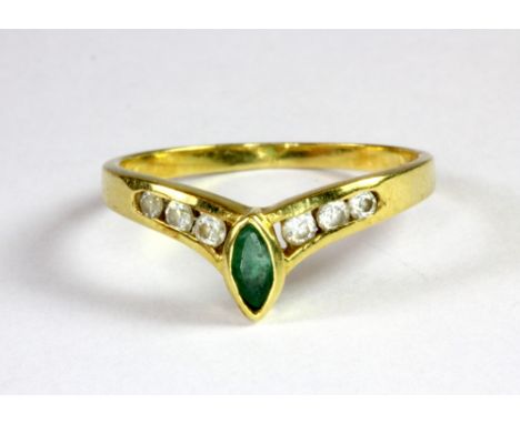 A yellow metal (tested 18ct) emerald and white stone set wishbone ring (O.5).