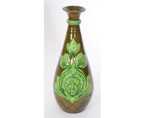 Ault Pottery - A late 19th Century vase of skittle form decorated to each side with a relief moulded face framed with stylise