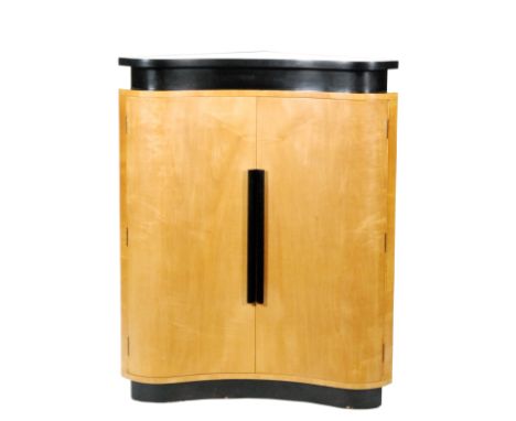 Unknown - A walnut veneered concave-fronted cocktail cabinet in the Art Deco style, with ebonised borders, the double doors e