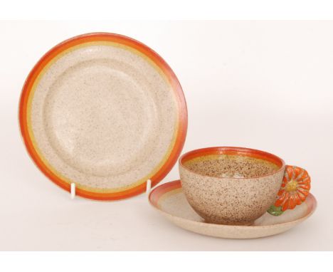 Clarice Cliff - Marguerite - A Goldstone cup, saucer and plate circa 1934, the cup having a relief moulded flower handle pick