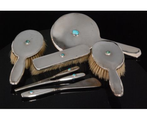 Liberty & Co - An Art Nouveau hallmarked silver Cymric dressing table set, each piece collar set with turquoise matrix caboch