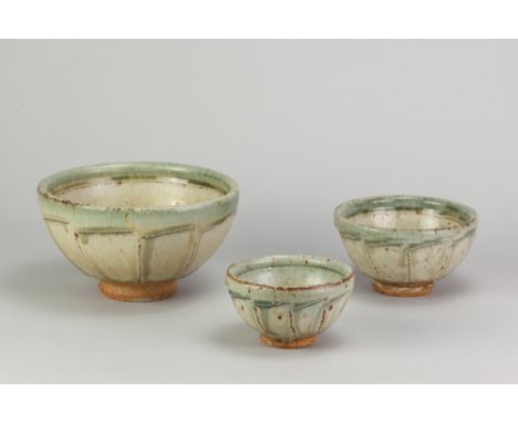 RICHARD BATTERHAM (1936-2021); a graduated trio of stoneware cut sided bowls covered in green ash glaze, largest diameter 17.