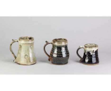 JIM MALONE (born 1946); three stoneware mugs covered in tenmoku breaking to kaki and nuka glaze, impressed JM and B (for Burn