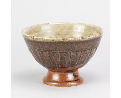 RICHARD BATTERHAM (1936-2021); a stoneware fluted tazza covered in green ash and tenmoku breaking to kaki glaze, diameter 15c