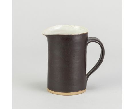 LUCIE RIE (1902-1995); a stoneware cream jug covered in manganese and pitted white glaze, impressed LR mark, height 9.5cm. (D