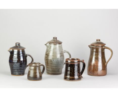 Leach Pottery; three stoneware coffee pots, a mug and a small jug covered in mottled grey and/or tenmoku breaking to kaki gla