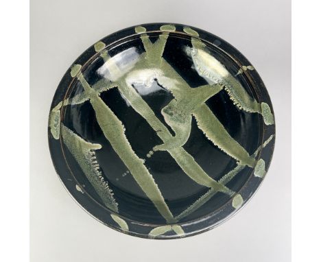 JIM MALONE (born 1946); a very large stoneware bowl covered in tenmoku breaking to kaki glaze with copper green pours, impres