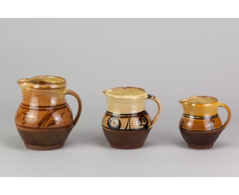PATRICK GROOM (born 1932) for Winchcombe Pottery; three slipware jugs with iron decoration on yellow ground, impressed PG and