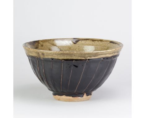 JIM MALONE (born 1946); a large stoneware fluted bowl covered in tenmoku and green ash glaze, impressed JM and A (for Ainstab