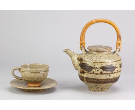 HUGH WEST (born 1950); a stoneware teapot with cane handle covered in oatmeal glaze with iron decoration, impressed HW mark, 