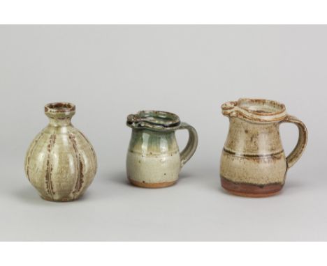 RICHARD BATTERHAM (1936-2021); two stoneware jugs covered in green ash glaze, tallest 11cm, and a small lobed bottle, height 