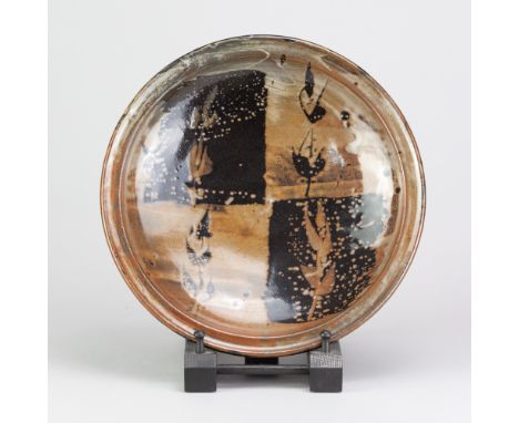 JIM MALONE (born 1946); a stoneware dish covered in tenmoku and kaki glaze with wax resist decoration, impressed JM and B (fo