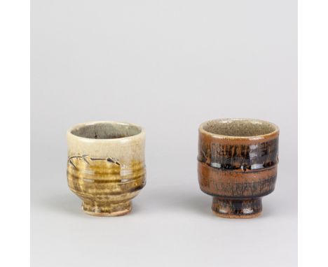 JIM MALONE (born 1946); two stoneware yunomi covered in tenmoku breaking to kaki glaze and green ash glaze with nuka top, imp