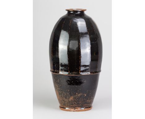 JIM MALONE (born 1946); a stoneware part faceted bottle covered in tenmoku breaking to kaki glaze, impressed JM and L (for Le