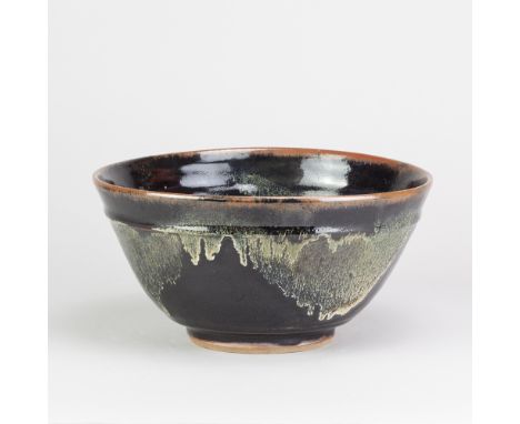 JIM MALONE (born 1946); a stoneware bowl covered in tenmoku breaking to kaki glaze with copper green pours, impressed JM and 