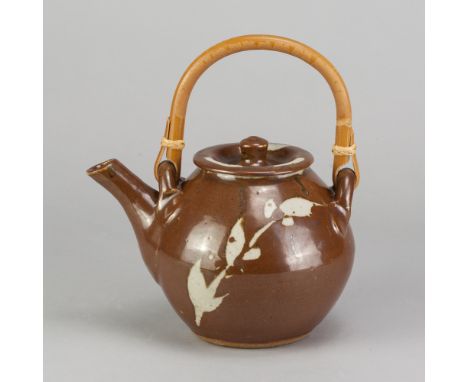 JIM MALONE (born 1946); a stoneware teapot with cane handle covered in kaki glaze with wax resist decoration, impressed JM an