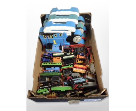 A group of Thomas the Tank Engine locomotives and carriages, in plastic boxes.