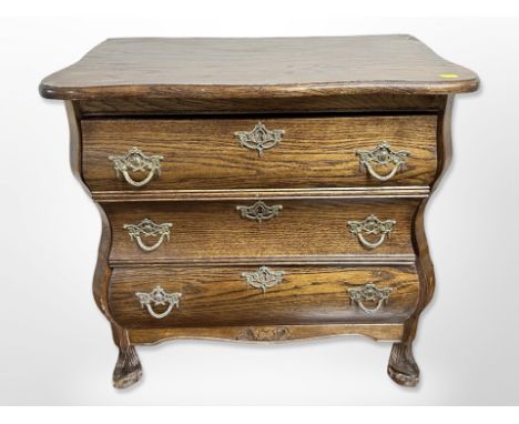 A continental oak three-drawer serpentine front bombe commode, 65 cm x 38 cm x 66 cm 