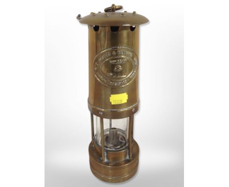 A brass E Thomas & Williams miner's lamp, number 5678.